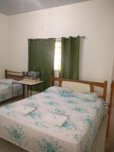 1 dormitorio con 2 camas y cortina verde en Pousada Rio Novo Jalapão en Mateiros
