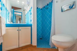 a blue bathroom with a toilet and a sink at Résidence Belvedere de Palombaggia in Porto-Vecchio