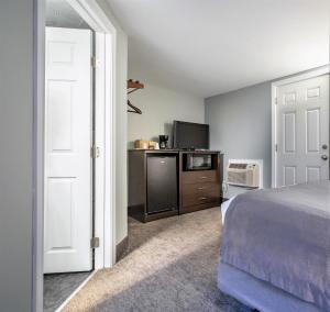 a bedroom with a bed and a tv and a microwave at Mt. Madison Inn & Suites in Gorham