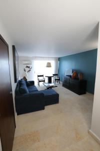 a living room with a couch and a blue wall at Hotel Montetaxco in Taxco de Alarcón