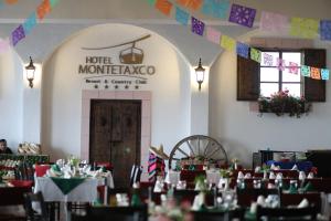 a restaurant with tables and chairs and a sign at Hotel Montetaxco in Taxco de Alarcón