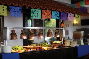 a buffet with food on a table with plates and vases at Hotel Montetaxco in Taxco de Alarcón