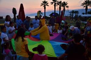 un grupo de personas de pie alrededor de una cometa en Afytos Akcay Tatil Koyu en Balıkesir