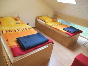 zwei Einzelbetten in einem kleinen Zimmer mit Fenster in der Unterkunft Järgen Ferienappartements in Koblenz