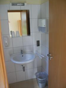 ein Badezimmer mit Waschbecken und Spiegel in der Unterkunft Järgen Ferienappartements in Koblenz