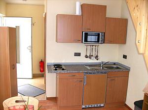 eine kleine Küche mit einer Spüle und einer Mikrowelle in der Unterkunft Järgen Ferienappartements in Koblenz