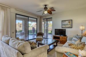 a living room with couches and a flat screen tv at Shores at Waikoloa #105 in Waikoloa