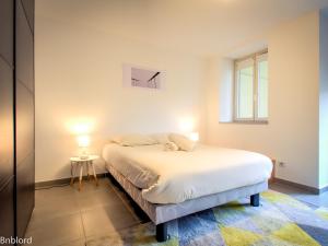 um quarto com uma cama branca e uma janela em Le Dunant em Estrasburgo