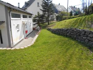 ein Haus mit einer Steinmauer neben einem Hof in der Unterkunft Järgen Ferienappartements in Koblenz