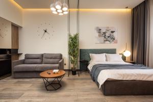 1 dormitorio con cama, sofá y reloj en Oldern House en Brasov