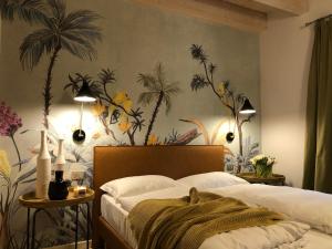 a bedroom with a mural of palm trees on the wall at Residence Relais Cà dell'Era in Tremosine Sul Garda +110 photos