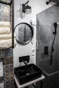 a bathroom with a black sink and a mirror at Apartament Wataha in Ustrzyki Dolne