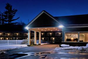 a building at night with snow on the ground at Mt. Madison Inn & Suites in Gorham