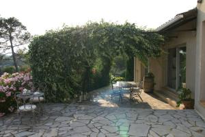 eine Terrasse mit einem Tisch und Stühlen unter einem Baum in der Unterkunft Elegante villa de 180m3 avec la superbe vue in Connaux