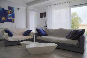 ein Wohnzimmer mit 2 Sofas und einem Couchtisch in der Unterkunft Elegante villa de 180m3 avec la superbe vue in Connaux