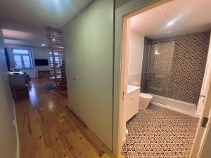 a bathroom with a shower and a toilet in a room at Vitoria's Terrace Apartments in Porto