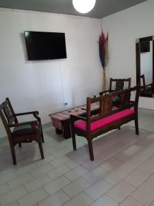 a room with two benches and a table and a tv at Departamento Plaza in San Salvador de Jujuy