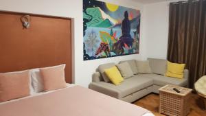 een kamer met een bed, een bank en een schilderij bij CASA RAIA in Braşov