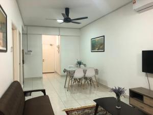 een woonkamer met een tafel en een plafondventilator bij Medina Homestay, Wakaf Che Yeh in Kota Bharu