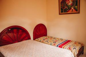 a bedroom with two beds with red headboards at Solar dos Borges in Carrancas