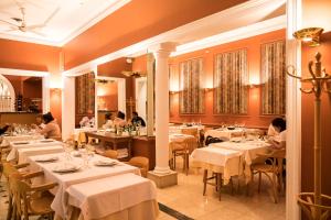 a restaurant with white tables and people sitting at them at Hotel Libertador in Tandil