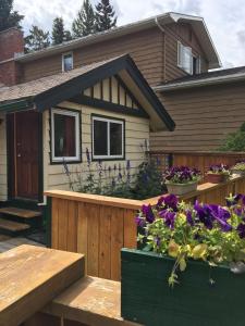 a house with flowers on a wooden deck at Hillside Bungalows in Banff