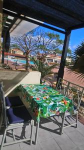 une table et des chaises assises sur une terrasse avec une table dans l'établissement Green Oasis by the pool, à Costa Calma