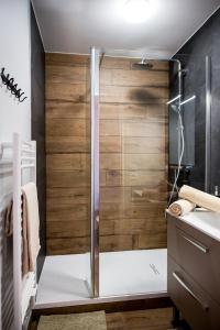 a shower with a glass door in a bathroom at Chic & Cosy Appartement avec Terrasse, Parking Privatif in Saint-Grégoire