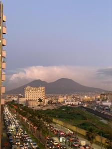 a busy city street filled with traffic with mountains in the background at Aurora Luxury Rooms in Naples