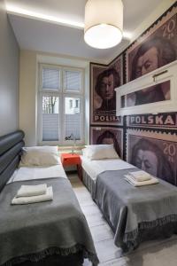 two beds in a room with posters on the wall at Yourplace M57 Apartments in Krakow
