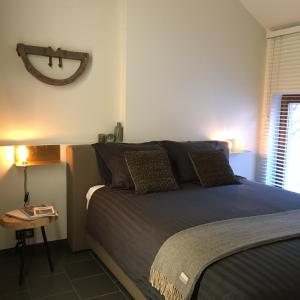 a bedroom with a bed and a side table at De Ruttermolen in Tongeren