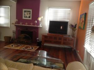 a living room filled with furniture and a fire place at Casablanca Enchanted Cottage in Nelson Bay