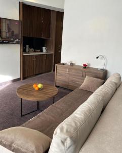 ein Wohnzimmer mit einem Sofa und einem Tisch in der Unterkunft Teddy Apartman Kula Konaci in Kopaonik