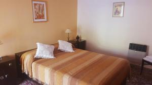 een slaapkamer met een bed met twee kussens erop bij Chalets La Lucinda in Cortaderas