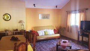 een woonkamer met een bank en een tv bij Chalets La Lucinda in Cortaderas