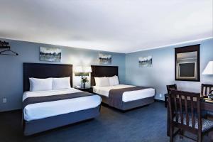 a hotel room with two beds and a desk at Mt. Madison Inn & Suites in Gorham +30 photos