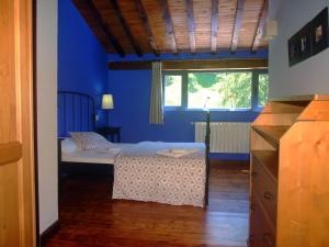 una camera con un letto in una camera blu di Las Hayucas a San Roque de Ríomiera