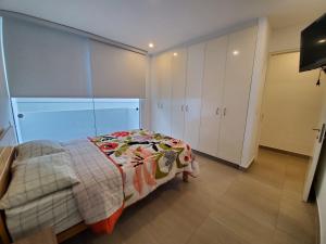 een slaapkamer met een bed en witte kasten bij Nuevo Condominio en Ocean Reef in San Bartolo