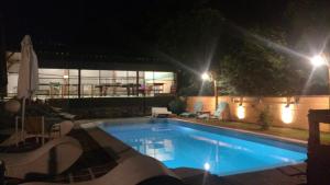 una gran piscina por la noche con luces en Cabañas Cangas de Onis MAYU SUMAJ en Villa Icho Cruz