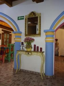a table with a mirror and a vase on it at Hotel Tierra Maya in San Cristóbal de Las Casas
