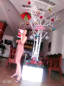 a woman standing in front of a christmas tree at Tien Vuong hotel in Thiện Chánh (1)