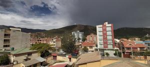 une ville avec des bâtiments et une montagne en arrière-plan dans l'établissement Garzonier Centrico, à Cochabamba