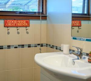 ein Badezimmer mit einem weißen Waschbecken und einem Spiegel in der Unterkunft Friends at McLaren Vale in McLaren Vale