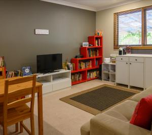 ein Wohnzimmer mit einem Sofa und einem TV in der Unterkunft Friends at McLaren Vale in McLaren Vale