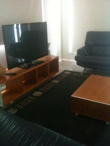 
a flat screen tv sitting on top of a wooden stand at Denman Serviced Apartments in Denman
