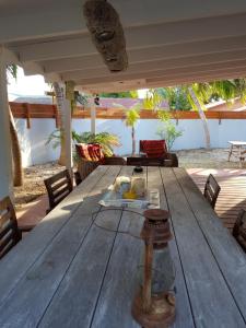 una gran mesa de madera en un patio con sillas en Charming home one block from the sea, en Willemstad