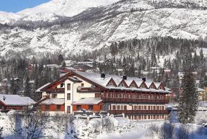 a large building covered in snow in front of a mountain at Fanitullen Hotel in Hemsedal