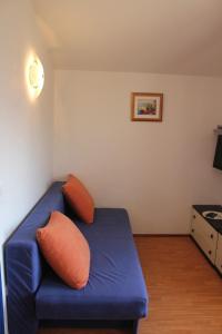 a blue couch with two pillows in a room at Apartments Ante - 50m from the sea in Posedarje