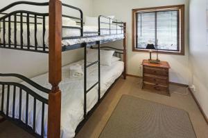 a bedroom with two bunk beds and a table at Mt Taylor Country Retreat in Mount Taylor