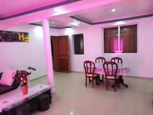 a dining room with a table and chairs and pink lighting at Casa Cabral : Big Apartment next to the beach in Tarrafal